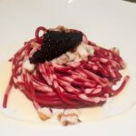 Piatto di spaghetti rosa con crema di parmigiano e sopra caviale