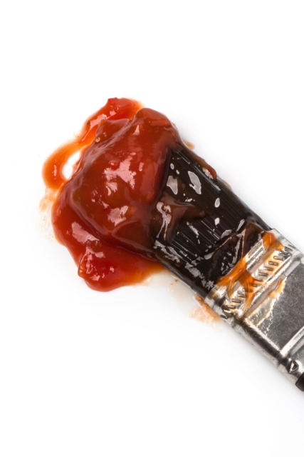 pennello impregnato di salsa barbecue su sfondo bianco