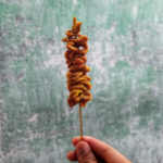 Spiedino di intestino tenuto in mano