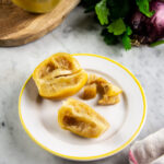 Un piatto con dentro un limone confit tagliato in 3 pezzi