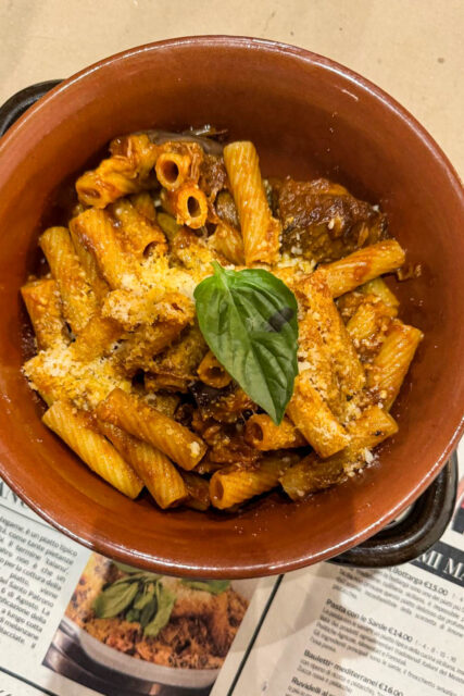 pasta, ragù di carne, melanzane e pecorino in un coccio