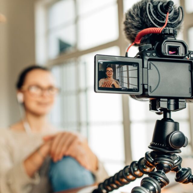 una donna sfocata dietro una telecamera