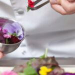 chef che tiene un fiore con una pinza